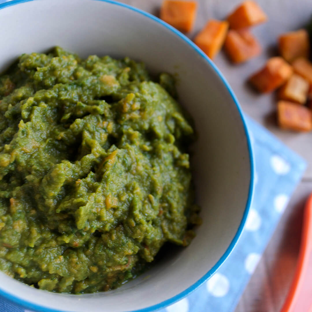 Roast Sweet Potato, Garlic & Kale Puree in a bowl with some roasted sweet potato on a roasting tray beside it